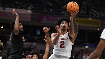 Mar 12, 2025; Indianapolis, IN, USA; Rutgers Scarlet Knights guard Dylan Harper (2) scores past USC Trojans guard Chibuzo Agbo (7) during the first half at Gainbridge Fieldhouse. Mandatory Credit: Robert Goddin-Imagn Images