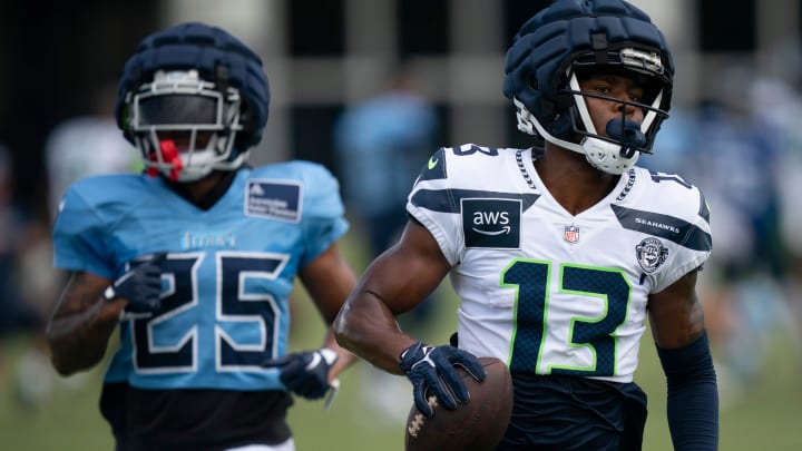 Seattle Seahawks wide receiver Easop Winston Jr. (13) runs after the catch when he beat Tennessee Titans running back Hassan Haskins (25) on the play at Ascension Saint Thomas Sports Park in Nashville, Tenn., Wednesday, Aug. 14 2024. This is the first day of the Titans joint practice with the Seattle Seahawks.