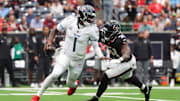 Sep 28, 2025; Houston, Texas, USA; Tennessee Titans quarterback Cam Ward (1) scrambles from Houston Texans defensive end Will Anderson Jr. (51) during the first half at NRG Stadium. Mandatory Credit: Troy Taormina-Imagn Images