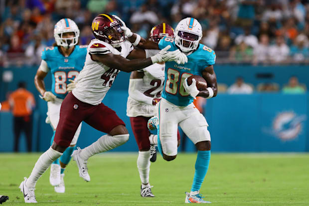 Miami Dolphins wide receiver Braylon Sanders stiff-arms Washington Commanders safety Dominique Hampton
