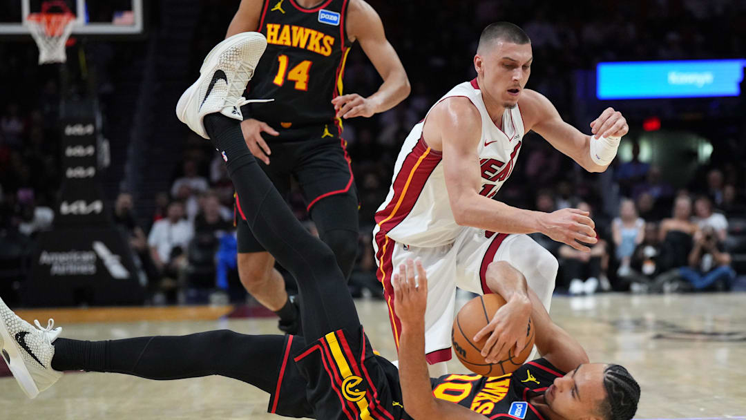 Apr 12, 2026; Miami, Florida, USA;  Atlanta Hawks forward Zaccharie Risacher (10) and Miami Heat guard Tyler Herro (14) battle for the ball during the first half at Kaseya Center. Mandatory Credit: Jim Rassol-Imagn Images