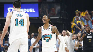 Apr 18, 2025; Memphis, Tennessee, USA; Memphis Grizzlies guard Ja Morant (12) reacts with center Zach Edey (14) during the first quarter against the Dallas Mavericks at FedExForum. Mandatory Credit: Petre Thomas-Imagn Images