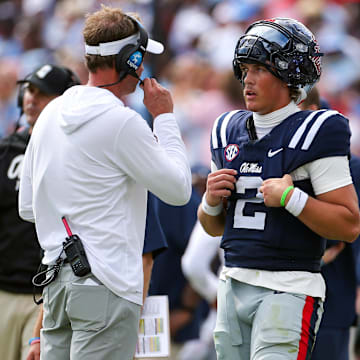 Oct 26, 2024; Oxford, Mississippi, USA; Mississippi Rebels head coach Lane Kiffin (left) talks with quarterback Jaxson Dart (2) during a time out during the second half against the Oklahoma Sooners at Vaught-Hemingway Stadium. Mandatory Credit: Petre Thomas-Imagn Images