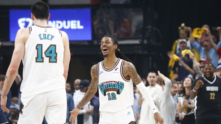 Apr 18, 2025; Memphis, Tennessee, USA; Memphis Grizzlies guard Ja Morant (12) reacts with center Zach Edey (14) during the first quarter against the Dallas Mavericks at FedExForum. Mandatory Credit: Petre Thomas-Imagn Images