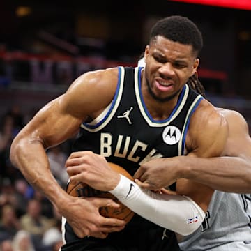 Jan 10, 2025; Orlando, Florida, USA; Milwaukee Bucks forward Giannis Antetokounmpo (34) and Orlando Magic center Wendell Carter Jr. (34) fight for a loose ball in the fourth quarter at Kia Center. Mandatory Credit: Nathan Ray Seebeck-Imagn Images