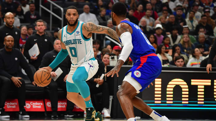 Dec 26, 2023; Los Angeles, California, USA; Charlotte Hornets forward Miles Bridges (0) moves the ball against Los Angeles Clippers forward Paul George (13) during the first half at Crypto.com Arena. Mandatory Credit: Gary A. Vasquez-USA TODAY Sports