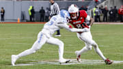 Nov 29, 2025; Raleigh, North Carolina, USA;  NC State Wolfpack wide receiver Keenan Jackson (8) runs with the ball guarded by North Carolina Tar Heels defensive back Tre Miller (15) during the second half of the game at Carter-Finley Stadium.  Mandatory Credit: Jaylynn Nash-Imagn Images