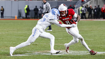 Nov 29, 2025; Raleigh, North Carolina, USA;  NC State Wolfpack wide receiver Keenan Jackson (8) runs with the ball guarded by North Carolina Tar Heels defensive back Tre Miller (15) during the second half of the game at Carter-Finley Stadium.  Mandatory Credit: Jaylynn Nash-Imagn Images