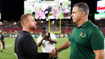 Sep 21, 2024; Tampa, Florida, USA;  Miami Hurricanes head coach Mario Cristobal greet South Florida Bulls head coach Alex Goulash after a game at Raymond James Stadium. Mandatory Credit: Nathan Ray Seebeck-Imagn Images