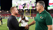 Sep 21, 2024; Tampa, Florida, USA;  Miami Hurricanes head coach Mario Cristobal greet South Florida Bulls head coach Alex Goulash after a game at Raymond James Stadium. Mandatory Credit: Nathan Ray Seebeck-Imagn Images
