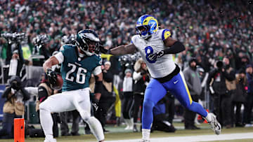 Jan 19, 2025; Philadelphia, Pennsylvania, USA; Philadelphia Eagles running back Saquon Barkley (26) scores a touchdown past Los Angeles Rams linebacker Jared Verse (8) in the first half in a 2025 NFC divisional round game at Lincoln Financial Field. Mandatory Credit: Bill Streicher-Imagn Images