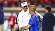 Nov 15, 2025; Oxford, Mississippi, USA; Mississippi Rebels head coach Lane Kiffin greets Florida Gators interim head coach Billy Gonzales during pregame warmups at Vaught-Hemingway Stadium. Mandatory Credit: Petre Thomas-Imagn Images