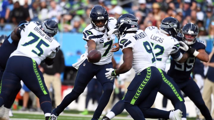 Dec 24, 2023; Nashville, Tennessee, USA; Seattle Seahawks quarterback Geno Smith (7) hands the ball off to running back Kenneth Walker III (9) during the second half against the Tennessee Titans at Nissan Stadium. Mandatory Credit: Christopher Hanewinckel-USA TODAY Sports