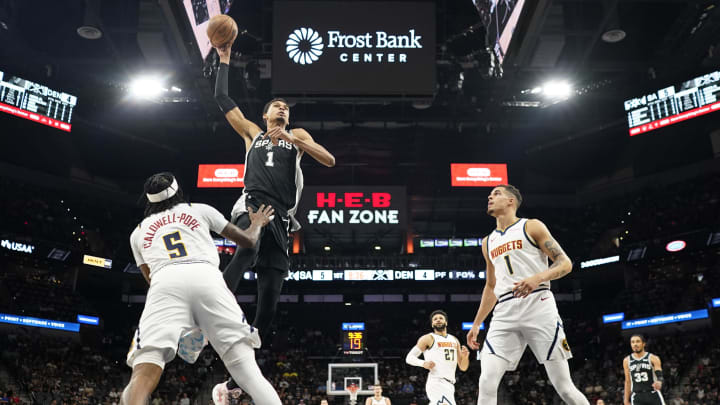 Apr 12, 2024; San Antonio, Texas, USA; San Antonio Spurs forward Victor Wembanyama (1) goes up to dunk over Denver Nuggets guard Kentavious Caldwell-Pope (5) and  forward Michael Porter Jr. (1) during the first half at Frost Bank Center.