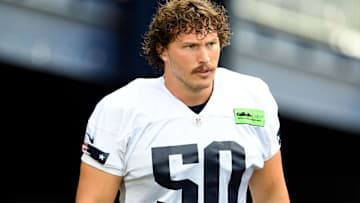 New England Patriots offensive lineman Cole Strange (50) walks onto the field before training camp at Gillette Stadium.