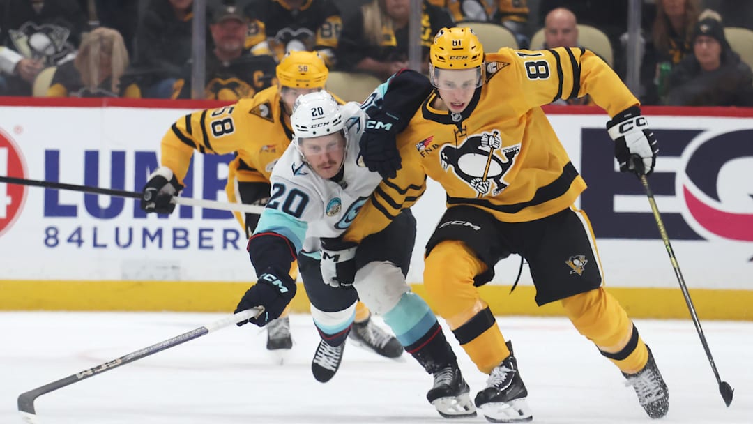 Nov 22, 2025; Pittsburgh, Pennsylvania, USA;  Seattle Kraken right wing Eeli Tolvanen (20) and Pittsburgh Penguins center Ben Kindel (81) chase the puck in overtime at PPG Paints Arena. Mandatory Credit: Charles LeClaire-Imagn Images