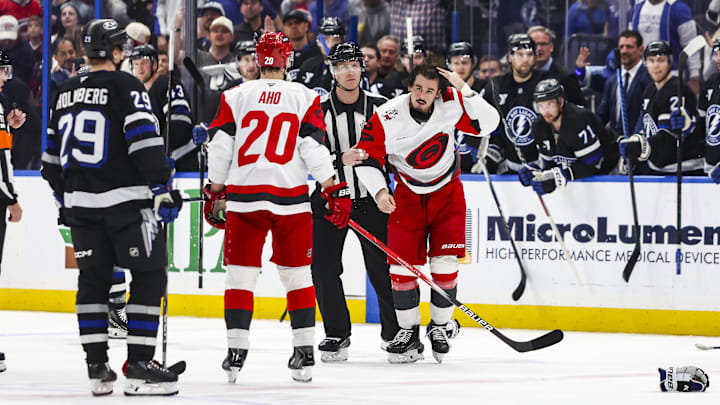 Mar 14, 2026; Tampa, Florida, USA; Carolina Hurricanes forward Seth Jarvis (24) is escorted to the penalty box after a fight with Tampa Bay Lightning forward Zemgas Girgensons (28) in the first period at Benchmark International Arena. Mandatory Credit: Morgan Tencza-Imagn Images