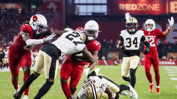 Cardinals running back Michael Carter (22) is hit by Saints defensive backs Will Harris (5) and Shemar Jean-Charles (27)