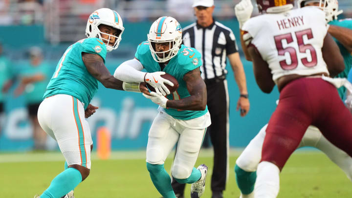 Aug 17, 2024; Miami Gardens, Florida, USA;  Miami Dolphins quarterback Tua Tagovailoa (1) hands off to running back Raheem Mostert (31) against the Washington Commanders during the first quarter at Hard Rock Stadium. Mandatory Credit: Jim Rassol-USA TODAY Sports