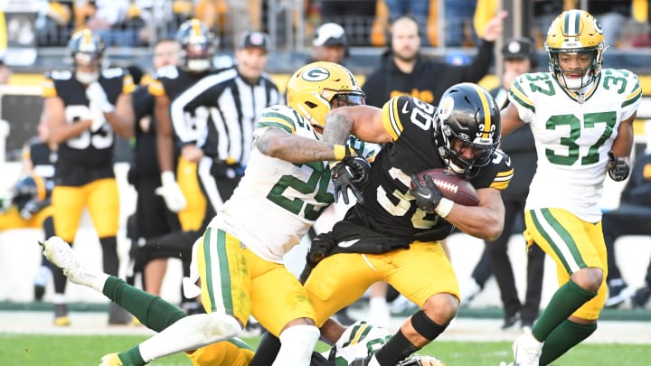 Nov 12, 2023; Pittsburgh, Pennsylvania, USA;  Pittsburgh Steelers running back Jaylen Warren (30) is tackled by Green Bay Packers cornerbacks Keisean Nixon (25) and Corey Ballentine (35) during the fourth quarter at Acrisure Stadium.