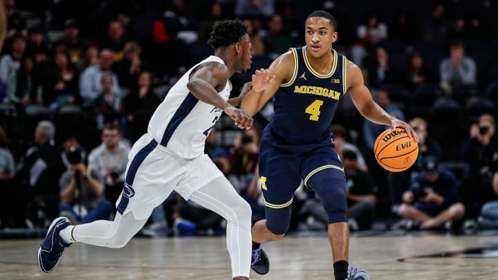 Michigan guard Nimari Burnett (4) dribbles against Penn State guard D'Marco Dunn (2) during the first half of the First Round of Big Ten tournament at Target Center in Minneapolis, Minn. on Wednesday, March 13, 2024.