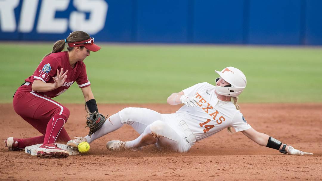 Jun 6, 2024; Oklahoma City, OK, USA; Texas Longhorns utility Reese Atwood slides safely into second as Oklahoma Sooners infielder Avery Hodge loses the ball. Jun 6, 2024; Oklahoma City, OK, USA; Texas Longhorns utility Reese Atwood slides safely into second as Oklahoma Sooners infielder Avery Hodge loses the ball.
