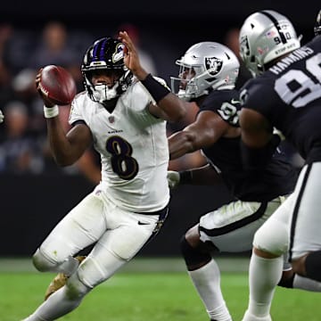 Sep 13, 2021; Paradise, Nevada, USA; Baltimore Ravens quarterback Lamar Jackson (8) runs the ball against Las Vegas Raiders defensive end Maxx Crosby (98) defensive end Yannick Ngakoue (91) and defensive tackle Johnathan Hankins (90) during the second half at Allegiant Stadium. Mandatory Credit: Mark J. Rebilas-Imagn Images