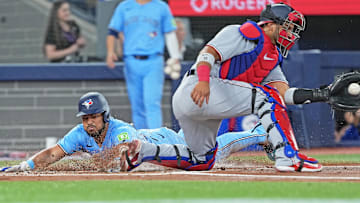 Apr 2, 2025; Toronto, Ontario, CAN; Toronto Blue Jays right fielder Anthony Santander (25) slides into home scoring a run ahead of the tag from Washington Nationals catcher Keibert Ruiz (20) during the first inning at Rogers Centre. Mandatory Credit: Nick Turchiaro-Imagn Images