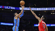 Oct 30, 2025; Oklahoma City, Oklahoma, USA; Oklahoma City Thunder guard Isaiah Joe (11) shoots a three point basket over Washington Wizards guard Tre Johnson (12) during the second half at Paycom Center. Mandatory Credit: Alonzo Adams-Imagn Images