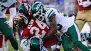 Sep 9, 2024; Santa Clara, California, USA; San Francisco 49ers running back Jordan Mason (24) is tackled by New York Jets safety Tony Adams (22) and New York Jets linebacker Quincy Williams (56) in the second quarter at Levi's Stadium. 
