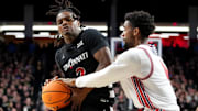 Cincinnati Bearcats guard Jizzle James (2) drives to the basket as Houston Cougars guard Mylik Wilson (8) defends in the first half of an NCAA college basketball game between the Houston Cougars and the Cincinnati Bearcats, Saturday, Feb. 10, 2024, at Fifth Third Arena in Cincinnati.