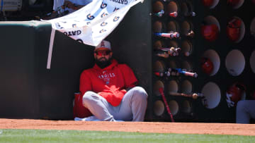 Jul 4, 2024; Oakland, California, USA; Los Angeles Angels  Luis Guillorme (15) under a shade structure made from a gatorade towel in the dugout during the first inning against the Oakland Athletics at Oakland-Alameda County Coliseum. Mandatory Credit: Kelley L Cox-USA TODAY Sports
