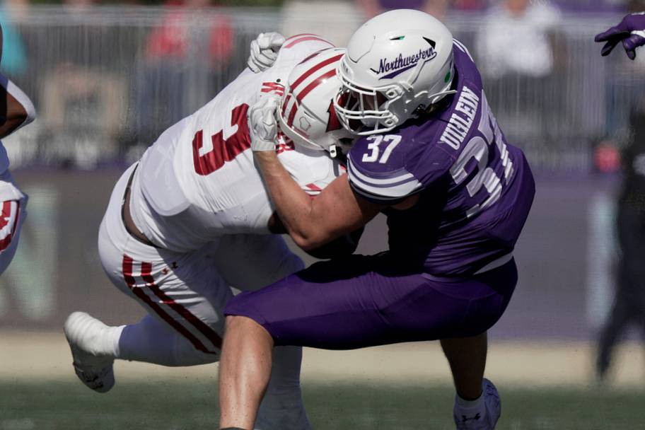 Northwestern linebacker Mac Uihlein stops Wisconsin running back Tawee Walker for no gain during a 2024 game. 