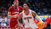 Arizona Wildcats guard Caleb Love (1) drives to the basket around Kansas Jayhawks guard Dajuan Harris Jr. (3) during the first half at Allen Fieldhouse.