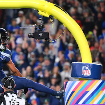Oct 20, 2025; Seattle, Washington, USA; Seattle Seahawks wide receiver Jaxon Smith-Njigba (11) celebrates on the goal post after a touchdown during the first quarter against the Houston Texans at Lumen Field.