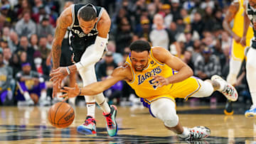 Former Los Angeles Lakers guard Talen Horton-Tucker (5) dives under San Antonio Spurs guard Dejounte Murray (5) for a loose ball in the first half at the AT&T Center.