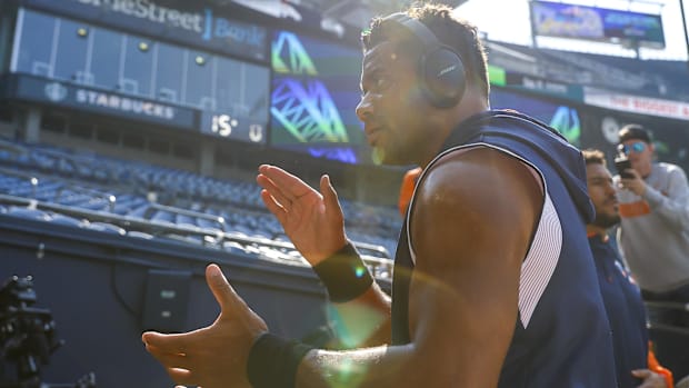 New York Giants quarterback Russell Wilson (blue and white shirt) gets fans pumped up before a game starts.