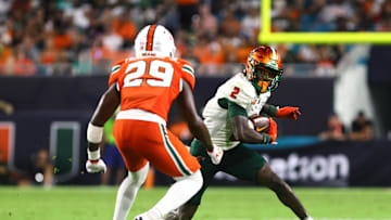 Sep 7, 2024; Miami Gardens, Florida, USA; Florida A&M Rattlers wide receiver Jamari Gassett (2) runs with the football against Miami Hurricanes defensive back OJ Frederique Jr. (29) during the third quarter at Hard Rock Stadium. Mandatory Credit: Sam Navarro-Imagn Images