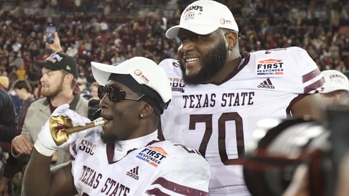 Dec 26, 2023; Dallas, TX, USA; Texas State Bobcats running back Ismail Mahdi (21) and offensive lineman Brey Walker (70) celebrate after the game against the Rice Owls at Gerald J Ford Stadium. Mandatory Credit: Tim Heitman-Imagn Images