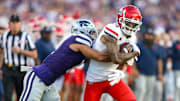 Sep 13, 2024; Manhattan, Kansas, USA; Arizona Wildcats wide receiver Tetairoa McMillan (4) is tackled by Kansas State Wildcats cornerback Keenan Garber (1) during the first quarter at Bill Snyder Family Football Stadium. 