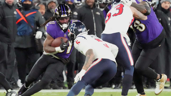 Jan 20, 2024; Baltimore, MD, USA; Baltimore Ravens running back Dalvin Cook (31) runs the ball against Houston Texans safety Jalen Pitre (5) during the fourth quarter of a 2024 AFC divisional round game at M&T Bank Stadium. Mandatory Credit: Mitch Stringer-USA TODAY Sports