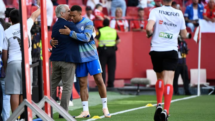 El director deportivo del Sevilla FC, Antonio Cordón, saluda afectuosamente al atacante del Real Madrid, Kylian Mbappé