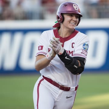 Jun 5, 2024; Oklahoma City, OK, USA;  Oklahoma Sooners catcher Kinzie Hansen (9) claps as she rounds the bases after hitting a two run home run in the third inning against the Texas Longhorns during game one of the Women's College World Series softball championship finals at Devon Park. Mandatory Credit: Brett Rojo-USA TODAY Sports