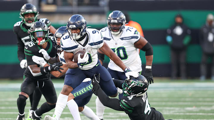 Dec 1, 2024; East Rutherford, New Jersey, USA; Seattle Seahawks running back Kenneth Walker III (9) is tackled by New York Jets cornerback D.J. Reed (4) during the second half at MetLife Stadium. Mandatory Credit: Vincent Carchietta-Imagn Images