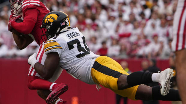 Wisconsin wide receiver Will Pauling (6) is tackled short of a first down by Iowa linebacker Jay Higgins (34).