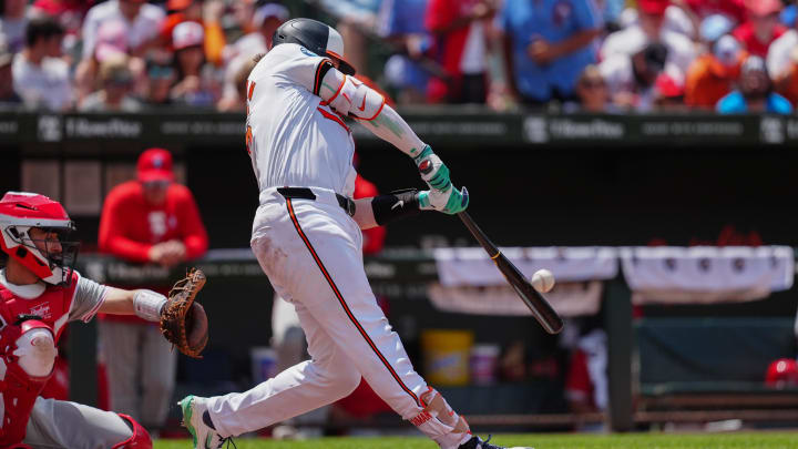 Jun 16, 2024; Baltimore, Maryland, USA; Baltimore Orioles catcher Adley Rutschman (35) hits a home run against the Philadelphia Phillies during the third inning at Oriole Park at Camden Yards. 