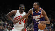 Mar 17, 2025; Phoenix, Arizona, USA; Phoenix Suns forward Kevin Durant (35) shields the ball from Toronto Raptors forward Jonathan Mogbo (2) in the second half at Footprint Center. Mandatory Credit: Rick Scuteri-Imagn Images
