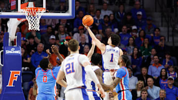 Mar 8, 2025; Gainesville, Florida, USA; Florida Gators guard Walter Clayton Jr. (1) makes a layup over Mississippi Rebels forward Malik Dia (0) during the first half at Exactech Arena at the Stephen C. O'Connell Center. Mandatory Credit: Matt Pendleton-Imagn Images