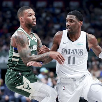 Mar 1, 2025; Dallas, Texas, USA;  Dallas Mavericks guard Kyrie Irving (11) controls the ball as Milwaukee Bucks guard Damian Lillard (0) defends during the first half at American Airlines Center. Mandatory Credit: Kevin Jairaj-Imagn Images