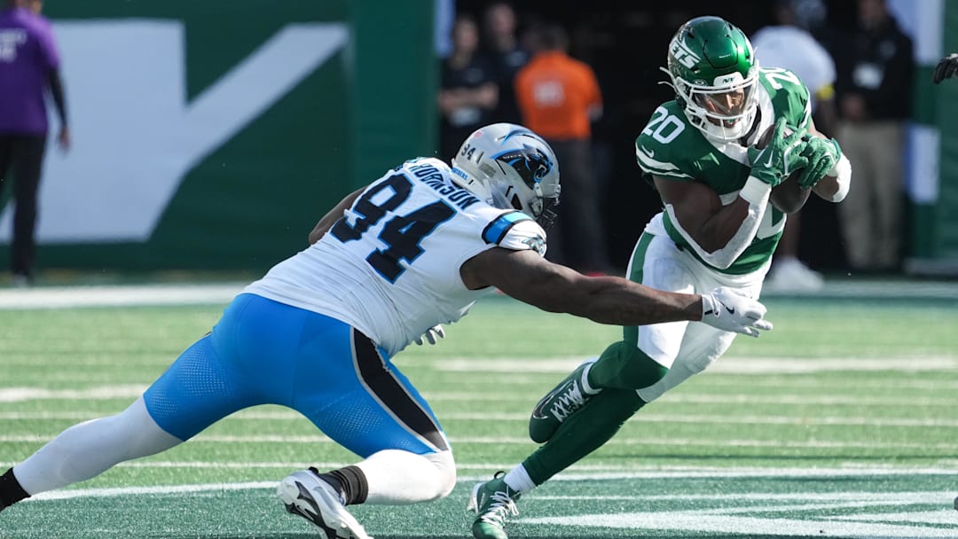 Breece Hall (20) runs with the ball while being defended by Carolina Panthers defensive end A'Shawn Robinson